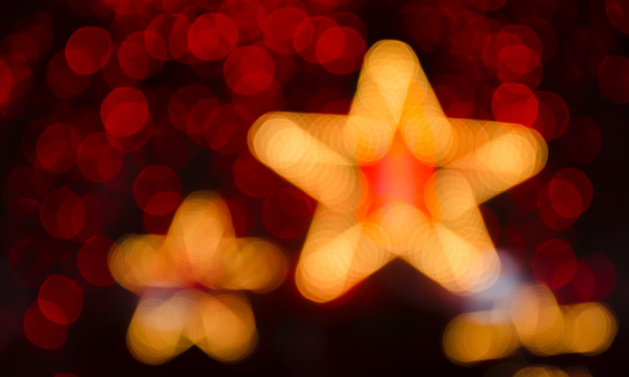 A photograph of a star-shaped light, softly glowing and appearing blurred or out-of-focus against a darker background